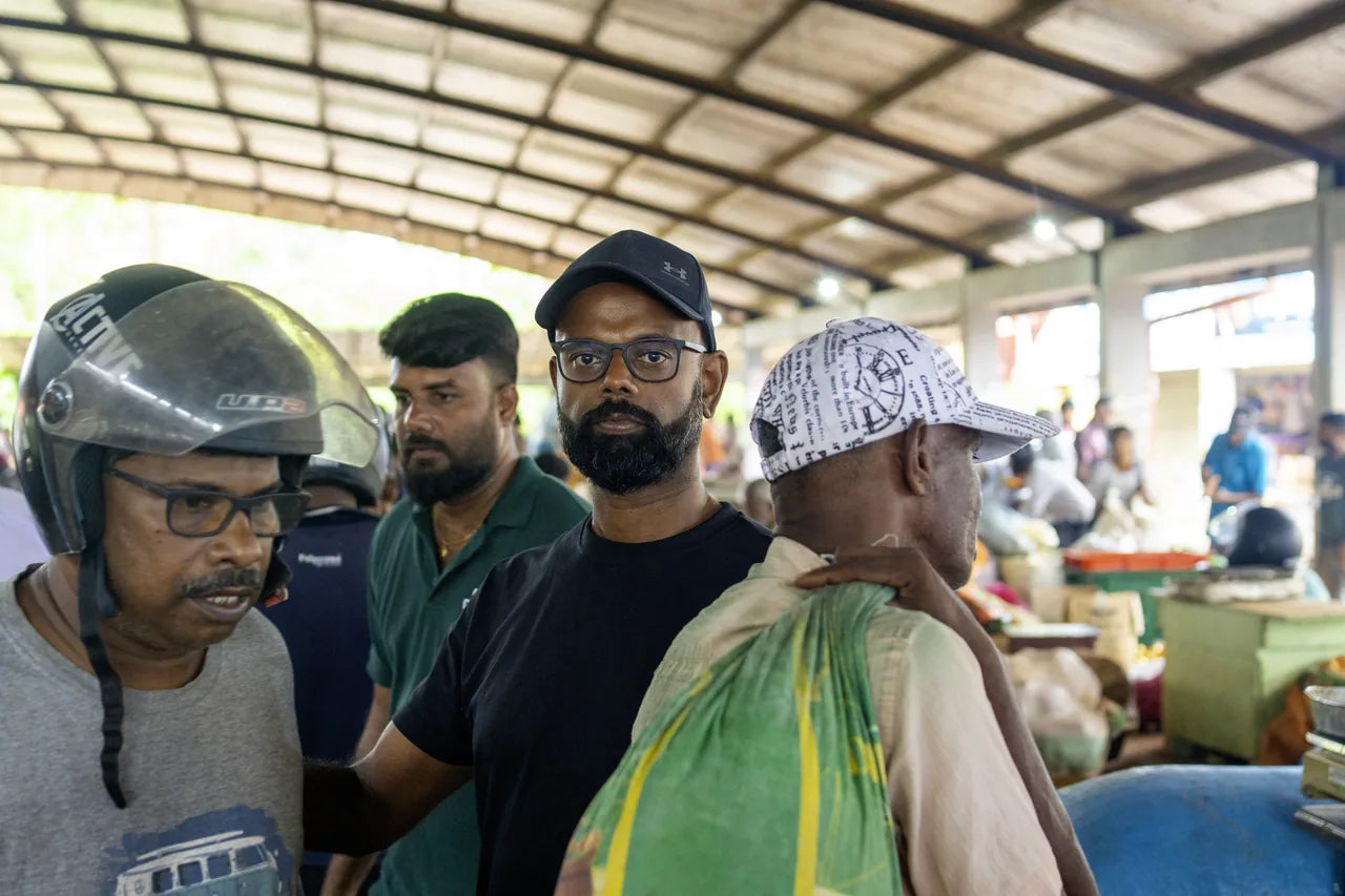 JR-Janathan Rajakumar im Marktgespräch mit zwei lokalen tamilischen Händlern auf dem Wochenmarkt in Jaffna im Norden Sri Lankas - persönlicher Austausch mit den Menschen vor Ort, direkter Bezug zur Lieferkette