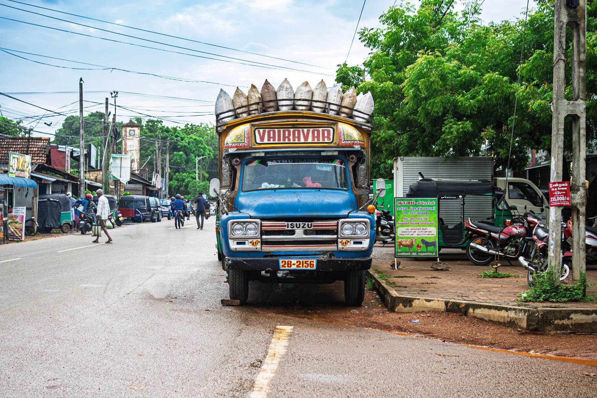 Bunt bemalter Lastwagen mit Säcken auf einer Straße in Jaffna im Norden Sri Lankas - MrCOLOMBO Reportage aus dem tamilischen Norden
